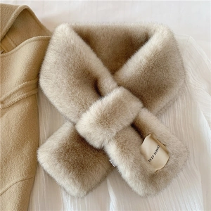 Detail of soft beige faux fur scarf with a SEZF SERVICE fabric label on white fabric
