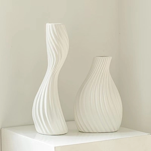Artistic white ceramic vases with flowing twisted textures in a minimalist home decor setting