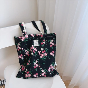 Detail of floral canvas tote bag with pink tulips on a white chair in a soft light setting