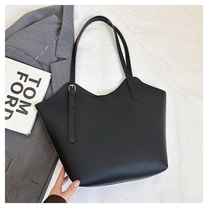 Dettaglio borsa tote nera a grana litchi con bordo ondulato e cinturino con fibbia alla moda