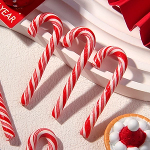 Close-up of red and white striped clay candy cane charms for DIY crafts and decor