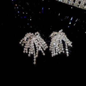 Macro shot of silver tassel earrings with sparkling rhinestones on black background