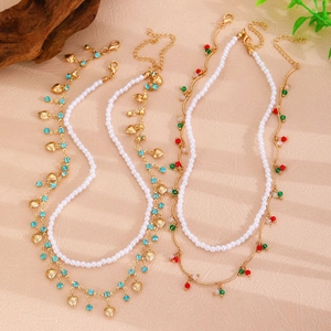Détail d'un collier doré multicouche avec perles, billes colorées et pendentifs coeur
