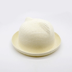 Detailed close-up of cream straw hat featuring cute cat ear design and woven texture