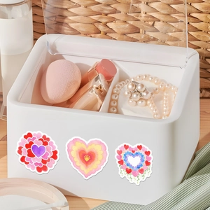 Close-up of a white desktop storage box with clear lid and heart stickers