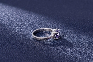 Macro shot of silver ring featuring heart-shaped purple amethyst and zircon stones