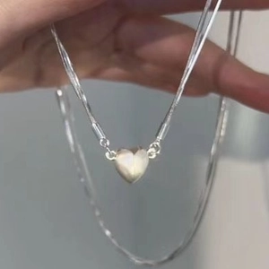 Layered silver snake chain necklace with sparkling diamond heart magnet pendant