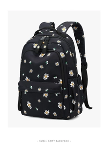 Side view of black nylon student backpack with small white and yellow daisy floral prints