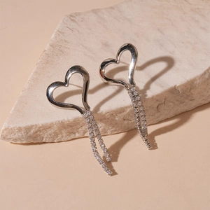 Detail shot of silver heart tassel earrings with micro-set diamonds on stone
