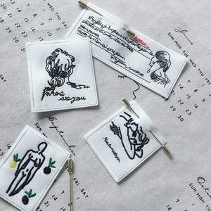 Macro view of four elegant fabric embroidered patches with chic artistic figure designs