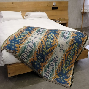 Detailed view of bohemian woven picnic blanket with geometric patterns and fringe tassels