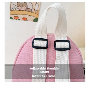 Detail view showing adjustable shoulder straps with black buckle on pink canvas backpack