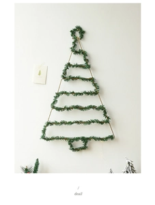 Detail of wall-mounted Christmas tree made of green pine needles and gold wire frame