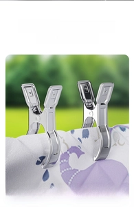 Close-up of heavy-duty stainless steel clips securing a thick quilt on a drying rack