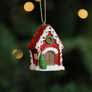 Red resin gingerbread house ornament with white snow details and golden string for Christmas