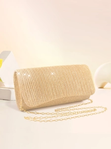 Macro view of golden pleated glitter evening clutch bag with fine metal chain strap