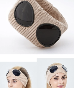 Close-up of ribbed knit headband in beige featuring integrated black goggles detail