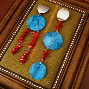 Detail of blue acrylic discs and red beads on vintage silver needle drop earrings