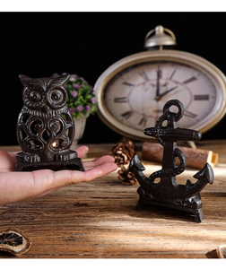Detail of vintage owl cast iron candle holder on wooden table with retro home decor