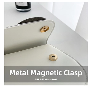 Close-up of a premium golden magnetic snap closure on a white PU leather owl bag