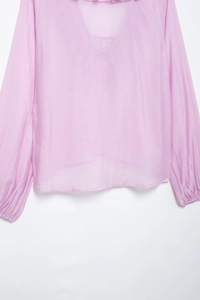 Detail of lavender chiffon blouse featuring a V-neck and elasticated cuffs texture
