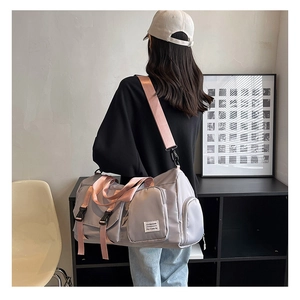 Light gray large travel bag with pink strap shown on model to display size and fit