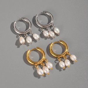 Détail de boucles d'oreilles créoles avec perles d'eau douce en argent et or 18K