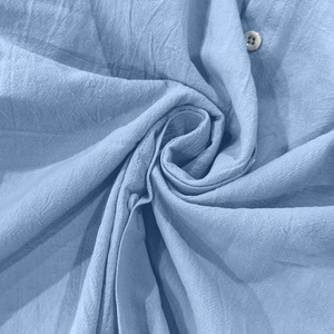 Detailed macro view of the blue cotton linen fabric texture with a button detail
