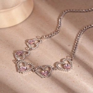 Elegant silver necklace with hollow heart links and pink zircon center stone with clear crystals