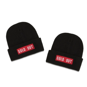 Fashionable black knit beanie with red 'SOLD OUT' embroidered patch for winter