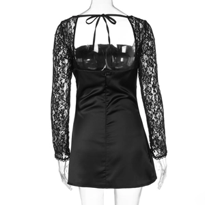 Detail of black satin mini dress featuring open back design and delicate lace sleeves