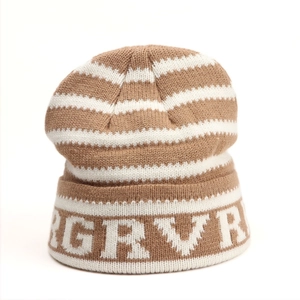 Détail du bonnet en tricot rayé marron et blanc avec motif jacquard de lettres GRVR