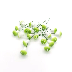 Miniature green dotted mushroom ornaments with wire stems for Christmas decor and DIY crafts