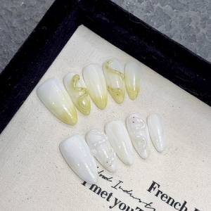 Faux ongles amande faits main avec dégradé jaune et motifs serpent en relief 3D