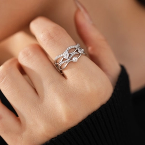 Nahaufnahme eines mehrlagigen Rings mit Perlen und Zirkonia-Pavé auf der Hand
