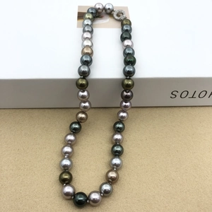Detailed close-up of peacock green and morandi multicolor pearls with diamond clasp