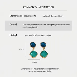 Vue détaillée des boucles d'oreilles en résine bleu et vert avec base en cuivre