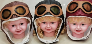 Detail view of children's pilot trapper hats in brown, black, and dark red faux leather