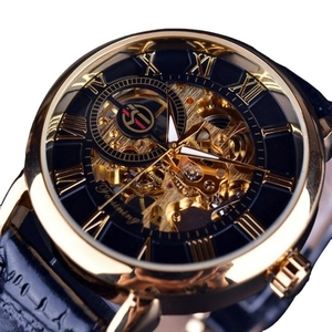 Vintage skeleton mechanical watch with golden case and black leather strap on macro view