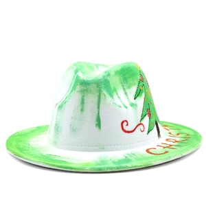 Détail d'un chapeau en feutre blanc avec taches vertes et motif de sapin de Noël