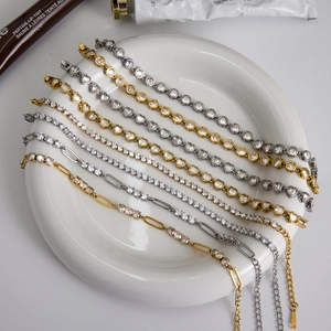 Detailed close-up of gold and silver stainless steel bracelets with zircon hearts in a ceramic bowl