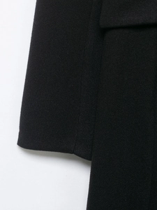 Close-up of black wool coat fabric showing fine texture and premium stitching detail