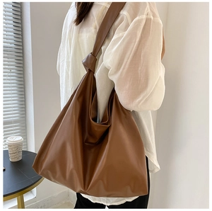 Detail of soft brown leather tote bag with wide knotted shoulder strap and large capacity
