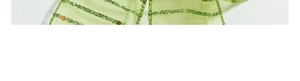 Macro view of green translucent gauze ribbon with glittering gold sequins for Christmas