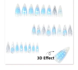 Détail de faux ongles stiletto Y2K avec dégradé bleu et motifs tribaux argentés en 3D