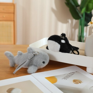 Detail of plush shark and whale keychains with soft faux fur texture and metal rings