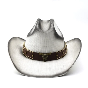 Detail of white woven cowboy straw hat featuring a brown leather band and bull head metal stud