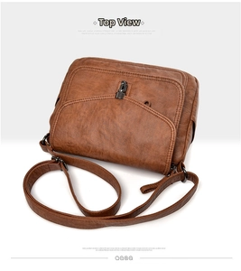Detail view of brown faux leather crossbody bag showing litchi texture and metal buckle