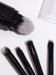 Detailed view of 5-in-1 multifunctional makeup brush with black handle and white tip bristles