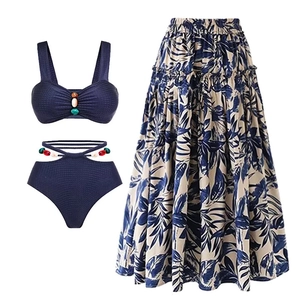 Detailed close-up of dark blue ribbed swimwear with colorful beads and tropical leaf skirt